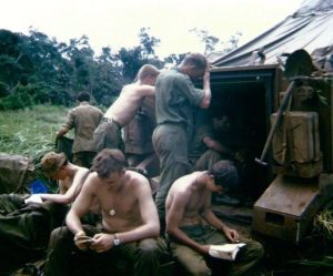 Fighting Tiger: Barry Giles (seated, far left with hat on), having a break at the rear of an armoured personnel carrier in Phouc Tuy province, the day after a battle and waiting to return to collect a compatriot's body, 1969.